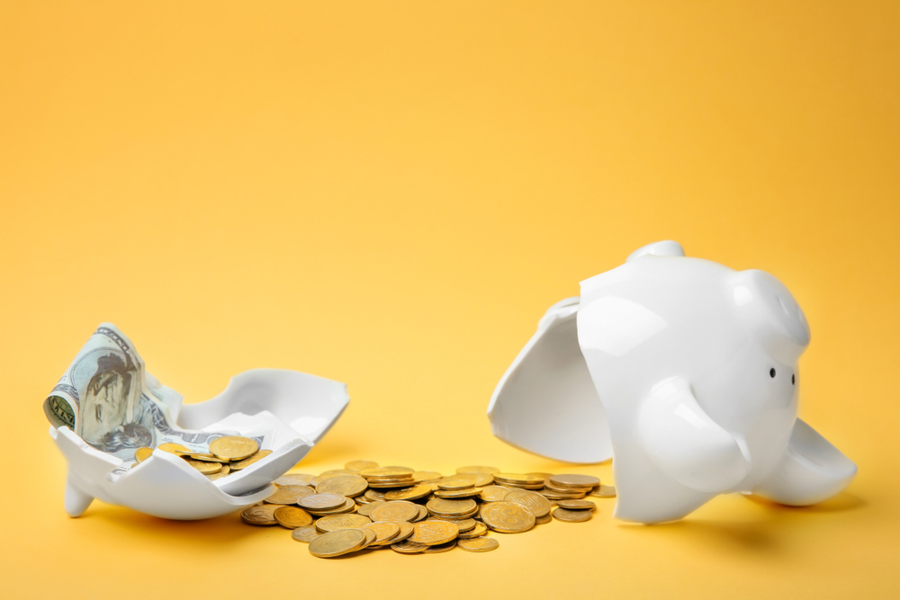 How will the cost of living crisis affect your marketing strategy? - Broken piggy bank on yellow background - Boom Online Marketing