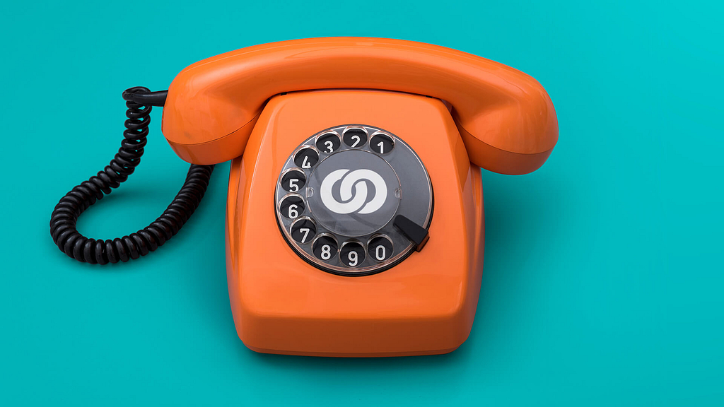 An orange phone on a turquoise background