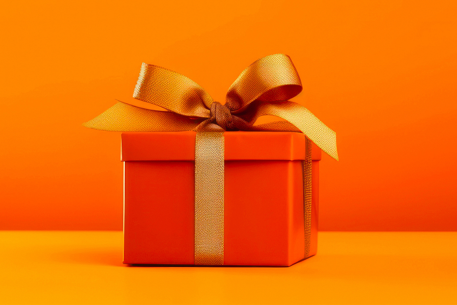 Orange gift box with golden ribbon and bow on orange background