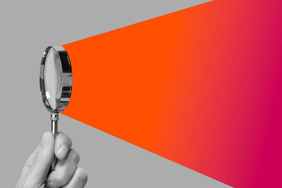A magnifying glass with a beam of orange emitting from the glass