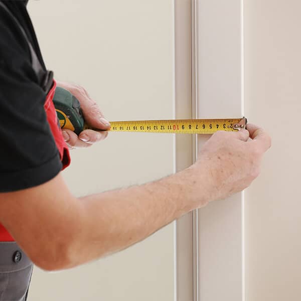 A person measuring a door frame
