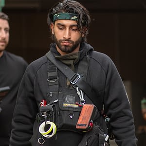 Riaz wearing our LED Chest Rig on a film set with gaffer tape attachments and light metre