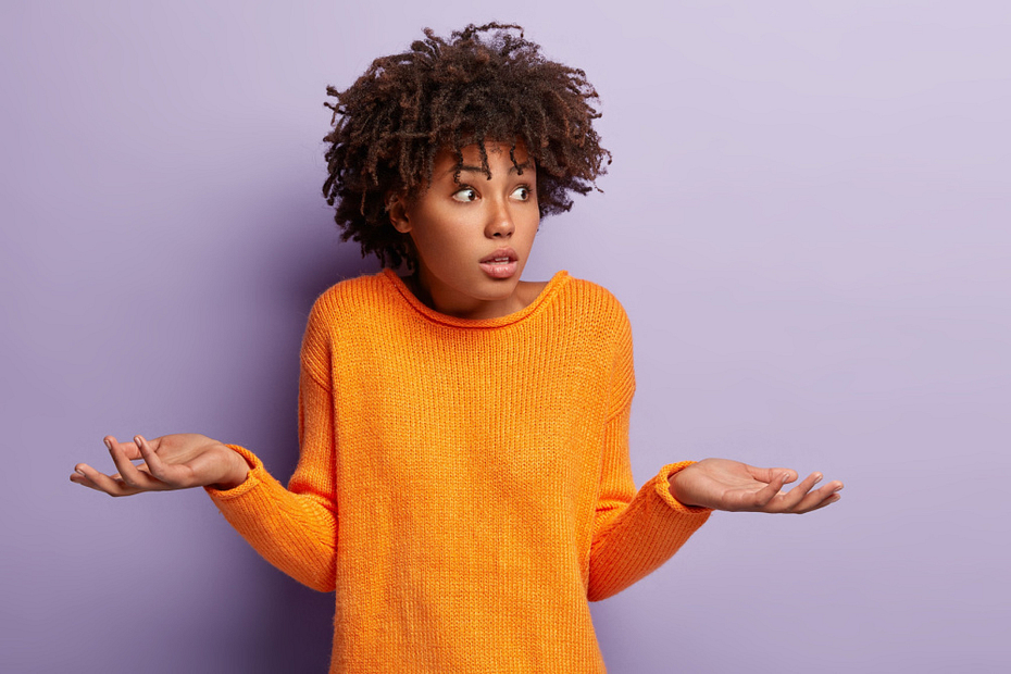 Woman in orange sweater on purple background - 6 Types of Unhelpful Content You Might Not Know You Have, and How To Improve Them - Boom Online Marketing