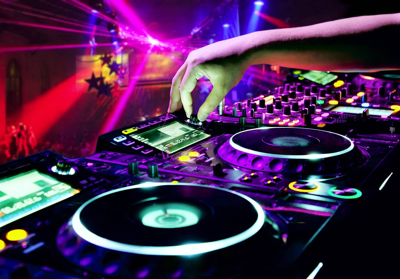 Dj mixes the track in nightclub at party